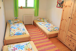 Schlafzimmer mit drei Einzelbetten im Ferienhaus